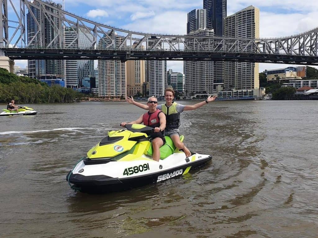 Alex and his dad on a jet ski in the Brisbane River